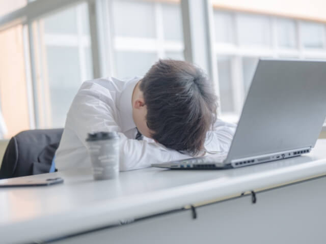 オフィスで疲れ切っている人をイメージした画像です。