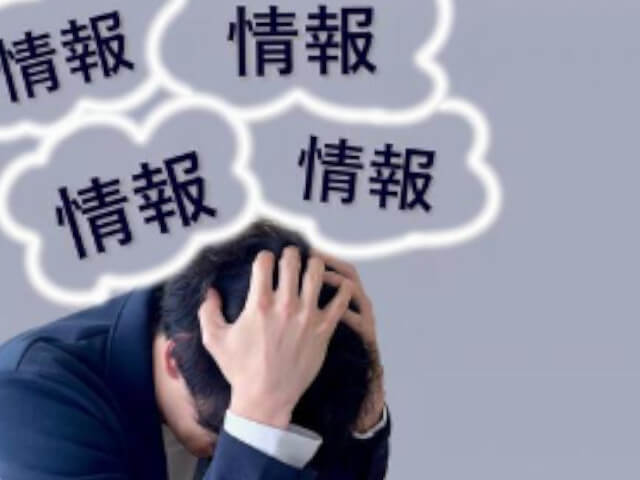 情報過多に頭を悩ませている男性をイメージした画像です。